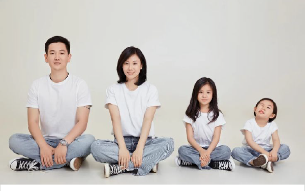 Hình ảnh gia đình 4 người hạnh phúc ngồi cùng nhau.