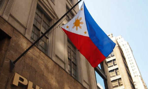 Hình ảnh quốc cờ Philippines được treo trước một tòa nhà cổ kính.